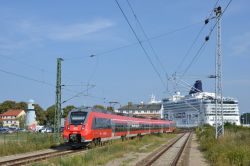 Deutsche Bahn DB Talent 2 ELektrotriebzug der S-Bahn Rostock als Linie S3 in Warnemünde mit Schiff und Leuchtturm